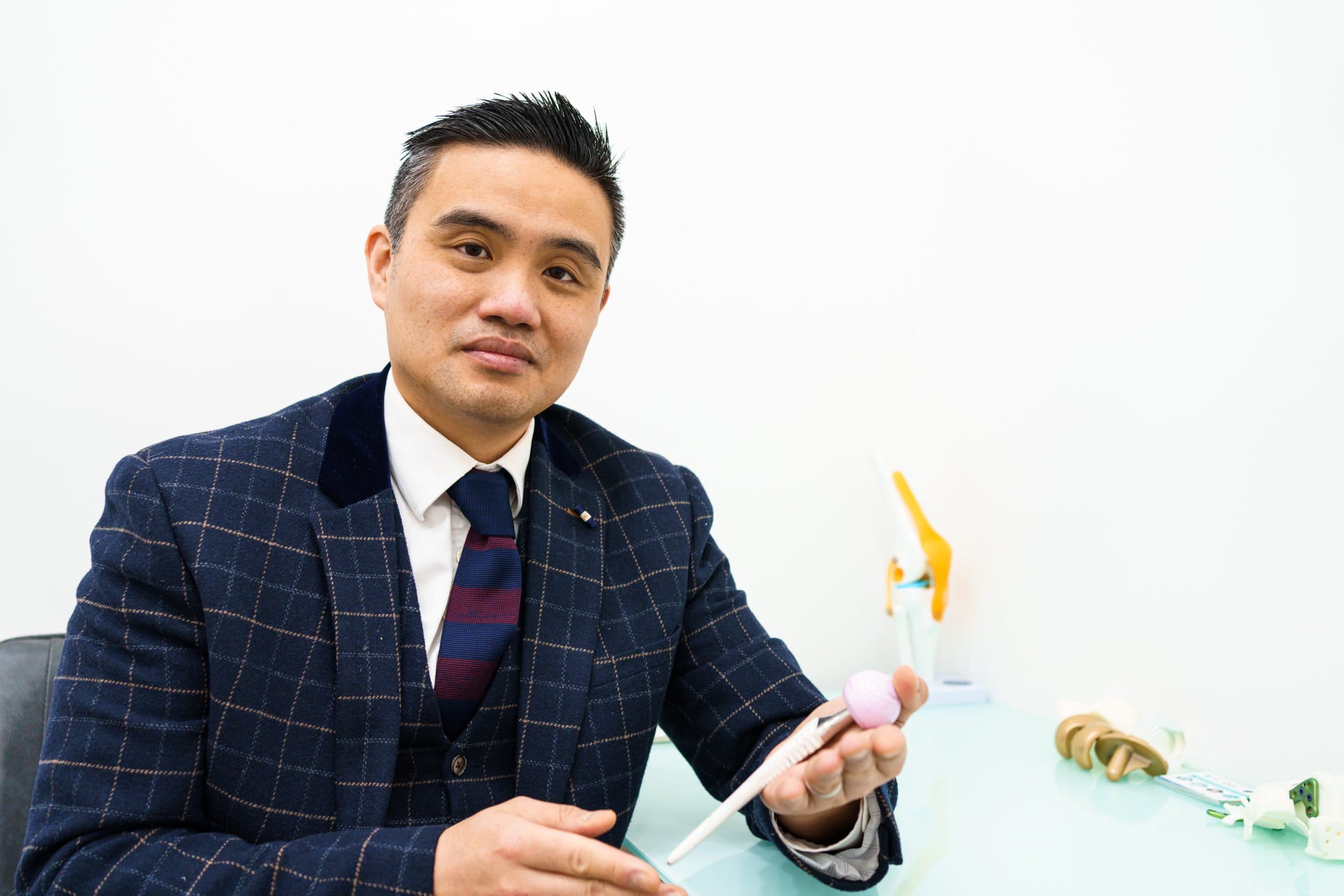 Doctor in checkered suit demonstrating implant