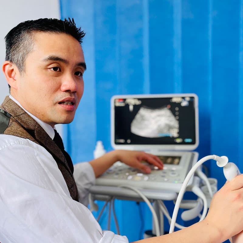Doctor operating ultrasound console in treatment room
